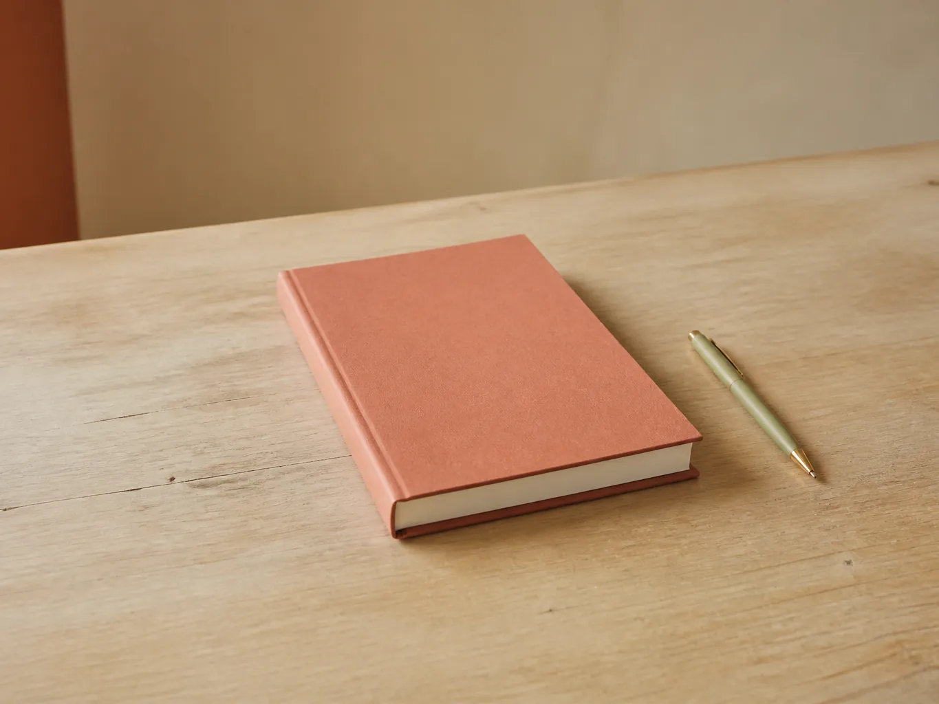 A new unopened notebook and a pen on an empty desk